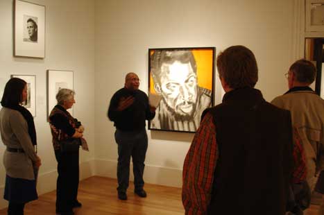 Reuben Jackson giving his talk, standing next to Ornette Coleman portrait