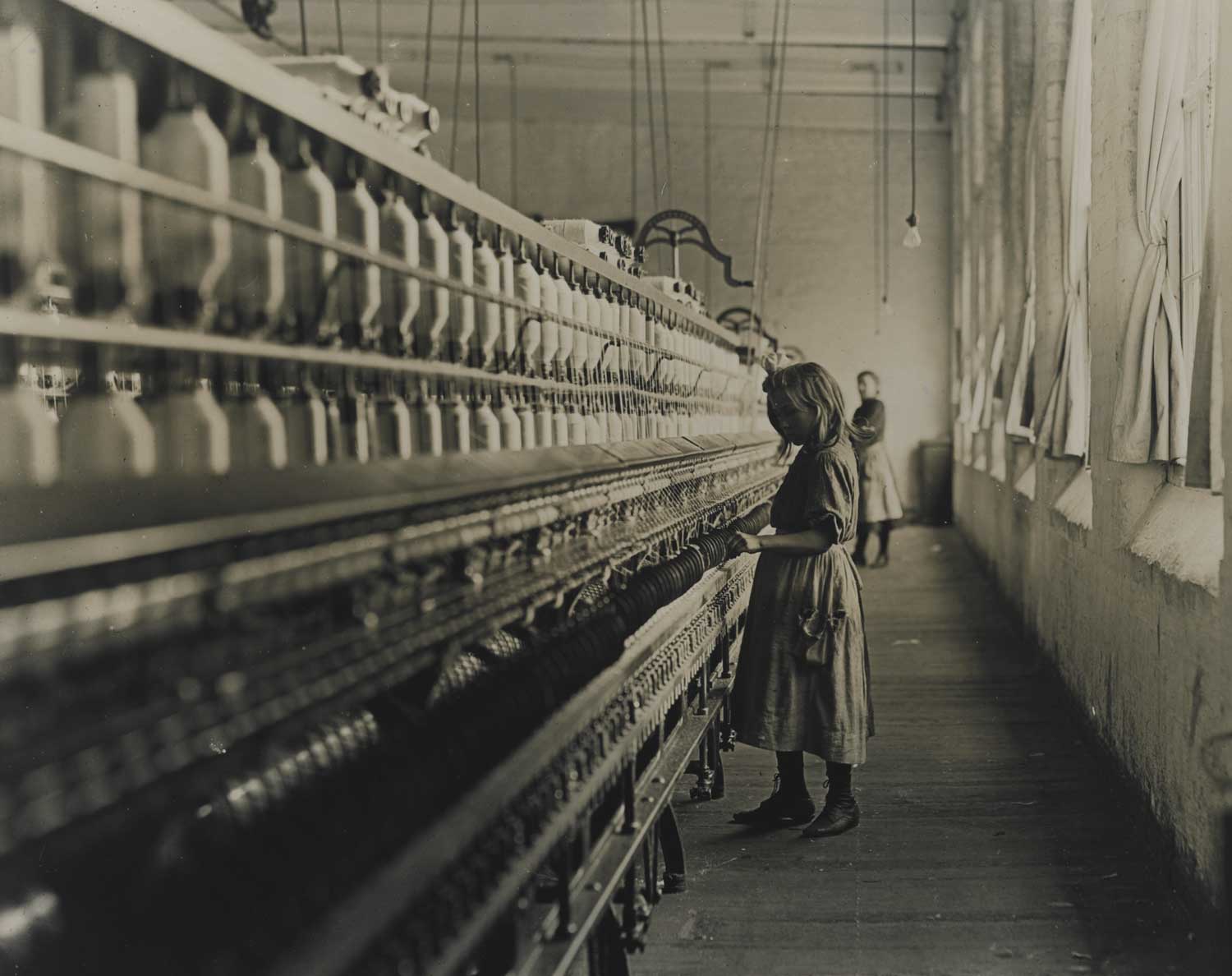 A photograph of a young girl operating machinery