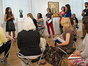 group of people listening to a lecture in a gallery