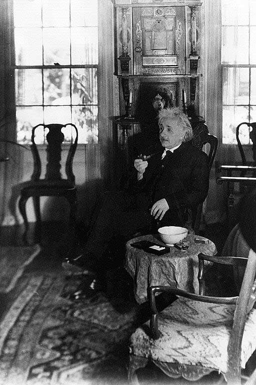A black and white photograph of a man sitting in a chair