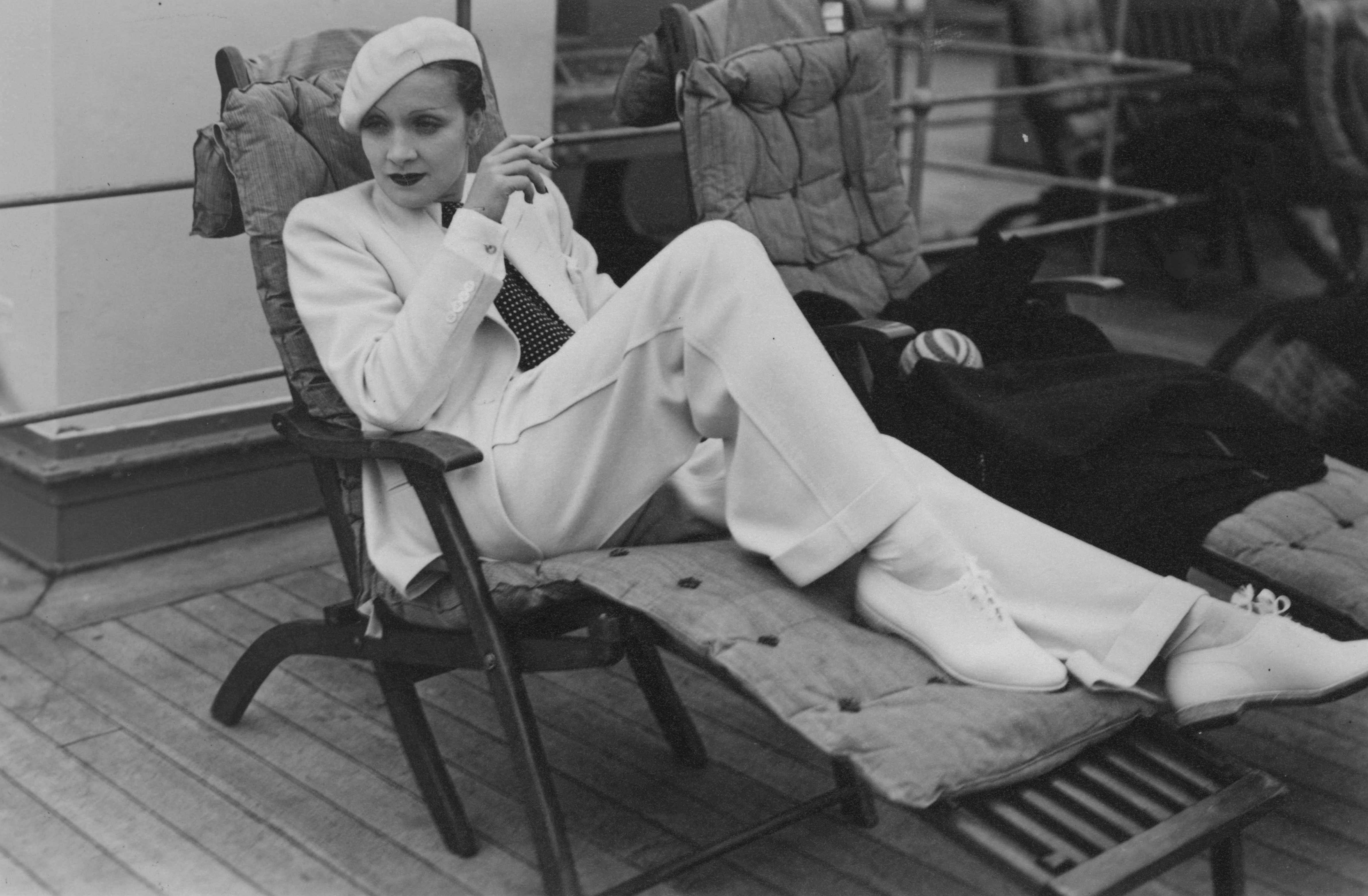 Black and white image of a woman smoking on a chaise lounge