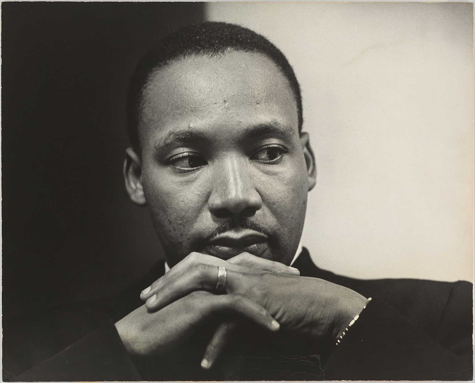 Black and white image of a man with his face resting on his hands