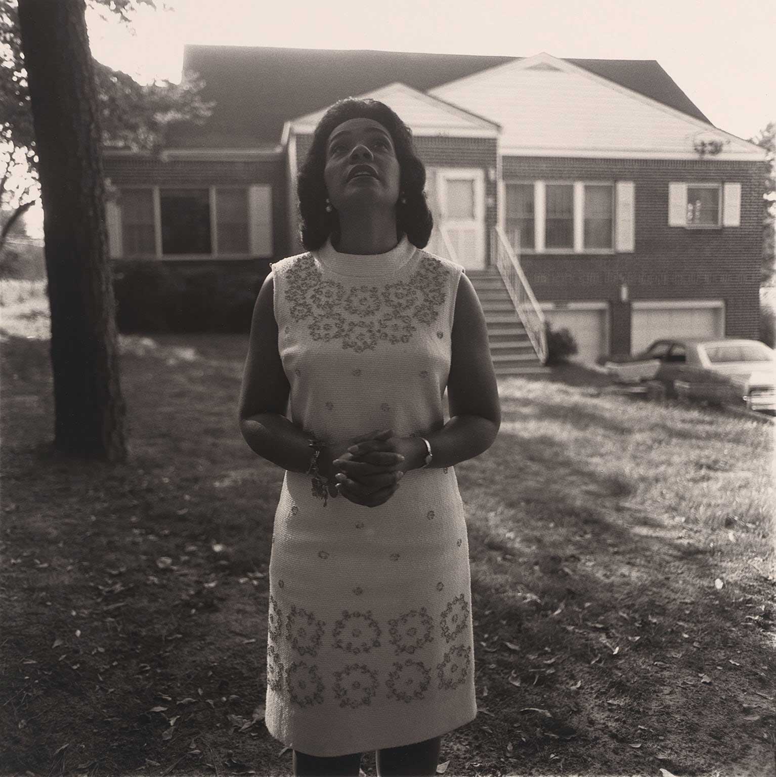 Black and white image of a woman looking towards the sky