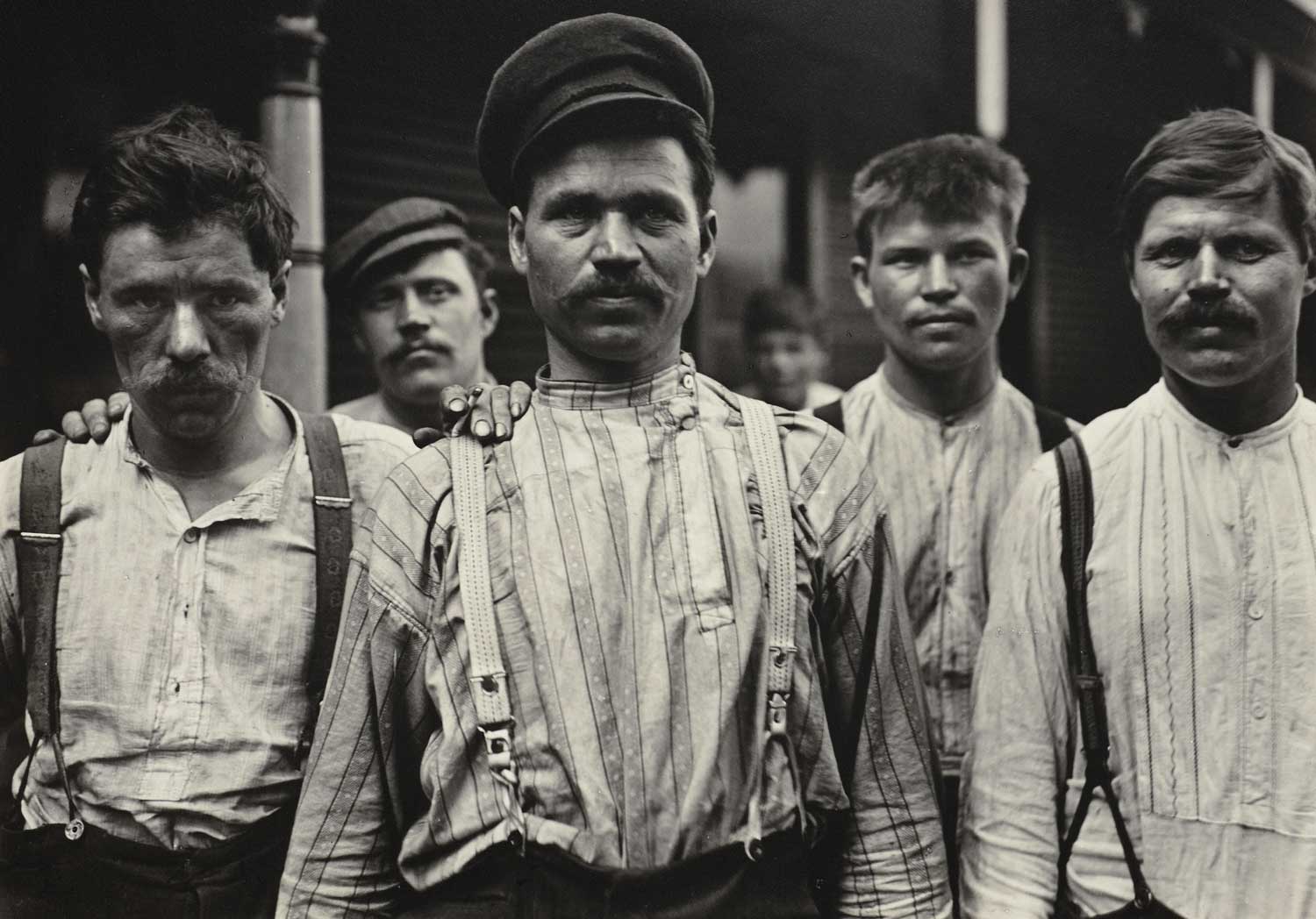 A black and white photograph of a group on men standing in a line