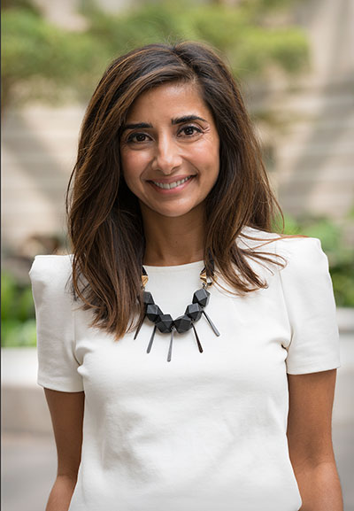 Asma Naeem headshot, courtyard in backgroud