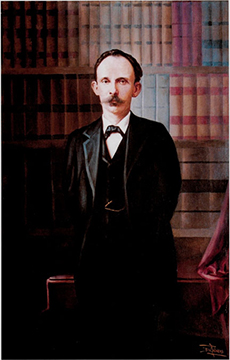 3/4 length portrait of a man with a moustache standing in a library