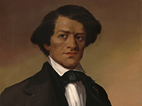 Bust length portrait of a young Black man in a black suit