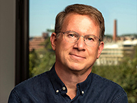 bust length view of a man with wire-rimmed glasses