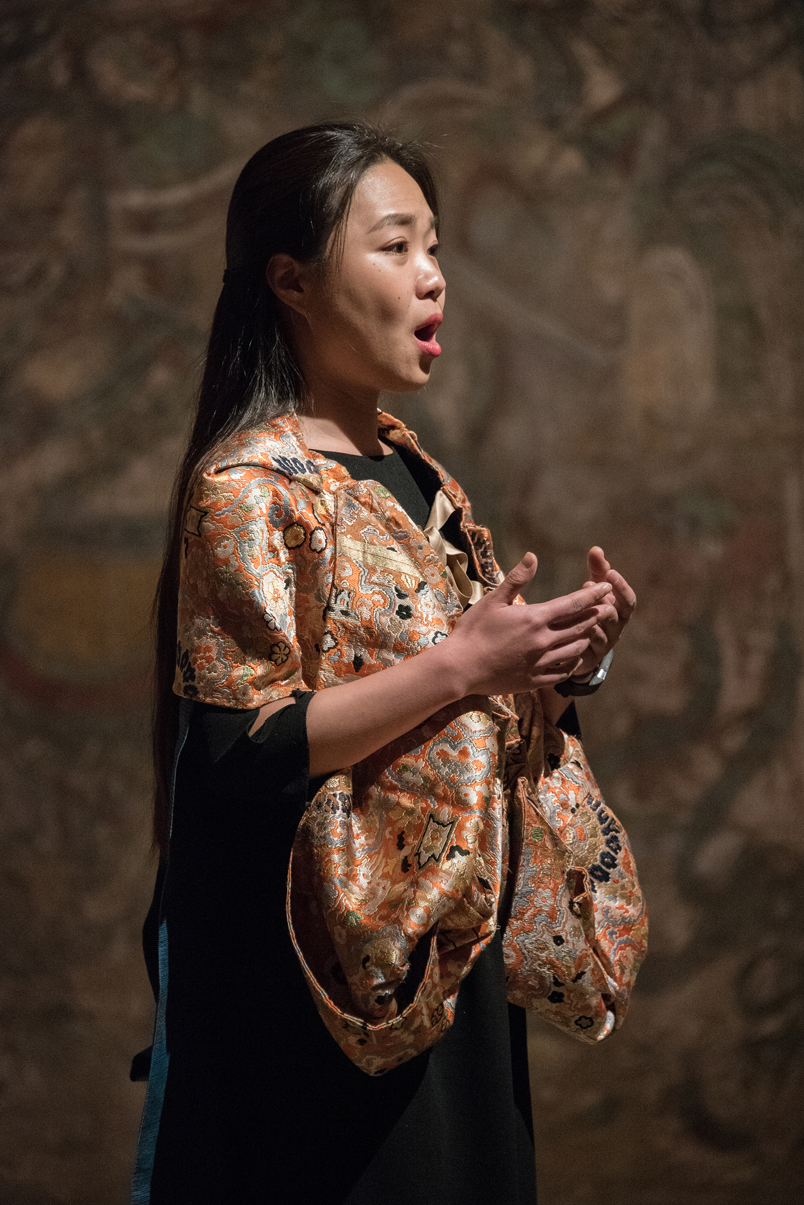 A photograph of a woman singing and wearing a beautiful robe