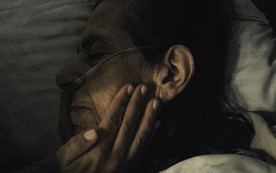 older woman in bed with oxygen tubes in her nose