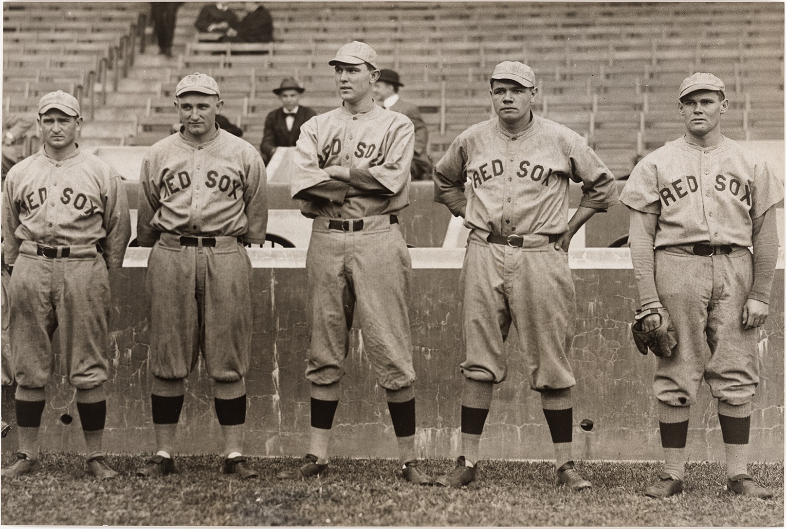 A black and white image of men wearing baseball uniforms standing in a row