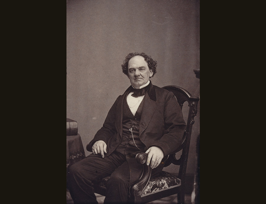 19th century man in a suit seated in a chair