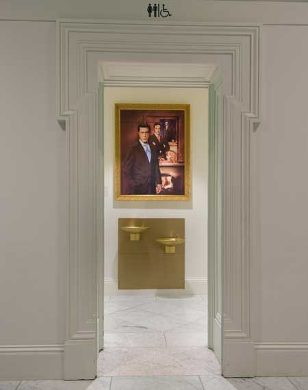 Stephen Colbert portrait, located above water fountains in bathroom alcove