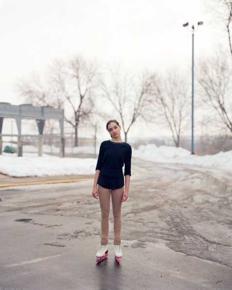 Girl on ice covered street wearing skates
