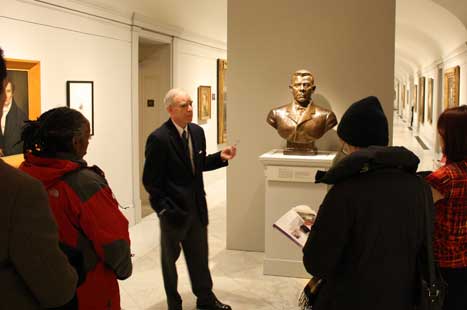 Historian Jim Barber giving a talk next to the bronze bust of Booker T. Washington