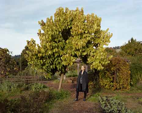 Photograph of Alice Waters with tree and garden in background