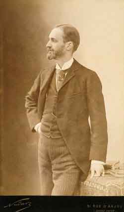 Photograph portrait of George Eastman, standing, wearing suit