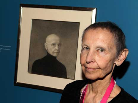 Martha Mayer Erlebacher in the Portrait Competition exhibit, standing next to her artwork