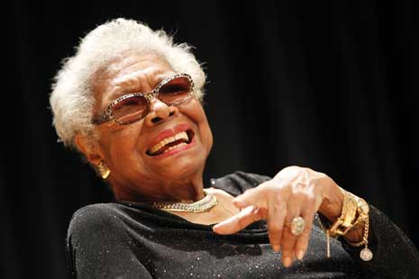 Color photo of Maya Angelou, smiling, wearing glasses.