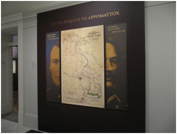 Color photo of an exhibition wall with map between two photographs of civil war military men.