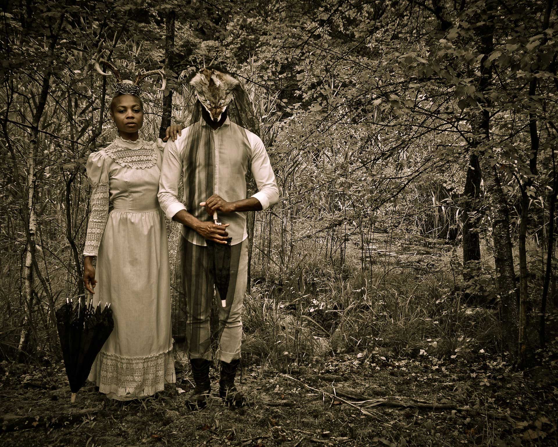 Sepia-toned photo of a woman in white and a man dressed as a fox