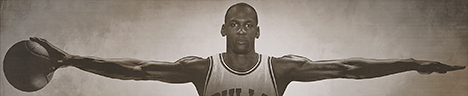 Jordan Black and white poster of Michael Jordan in his Bulls basketball uniform with arms outstretched, holding a basketball in his right hand, from front.