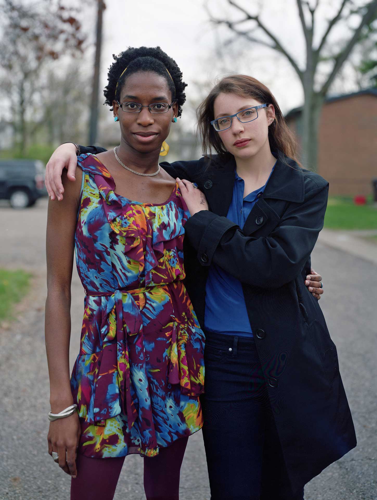 Two girls embracing and staring straight into the camera