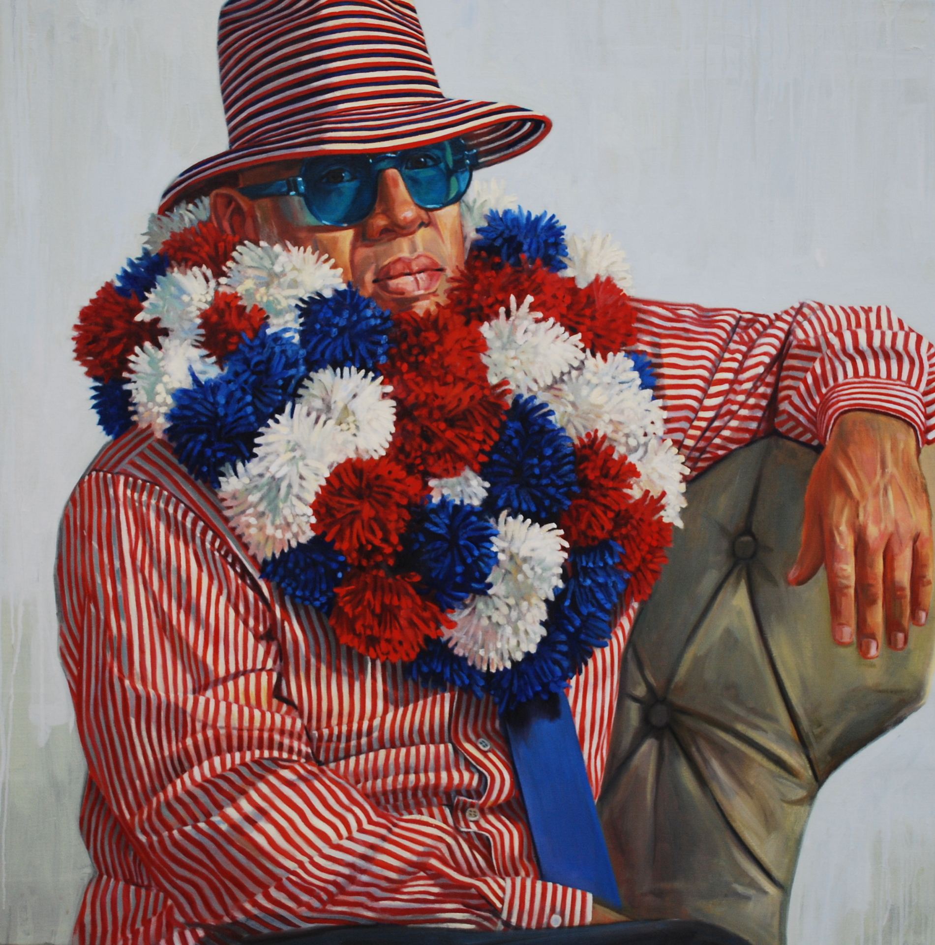 Man wearing red white and blue pom poms around his neck