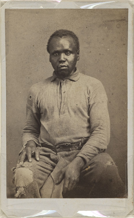 Blog_bound_freedoms_light_abraham Photograph portrait of Abraham, sitting, and in tattered shirt and pants with holes at the knees