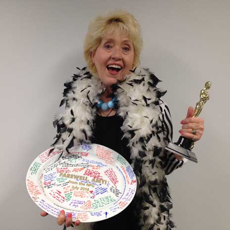 Amy Henderson, wearing feather boa and with replica Oscar in her hand