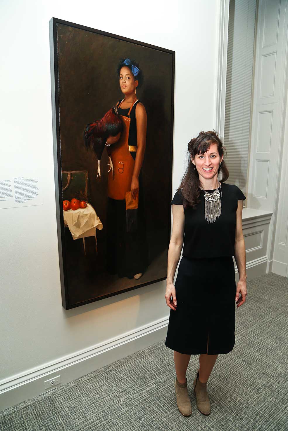 Artist Kelly Carmody standing in front of her work "Woman with Rooster"