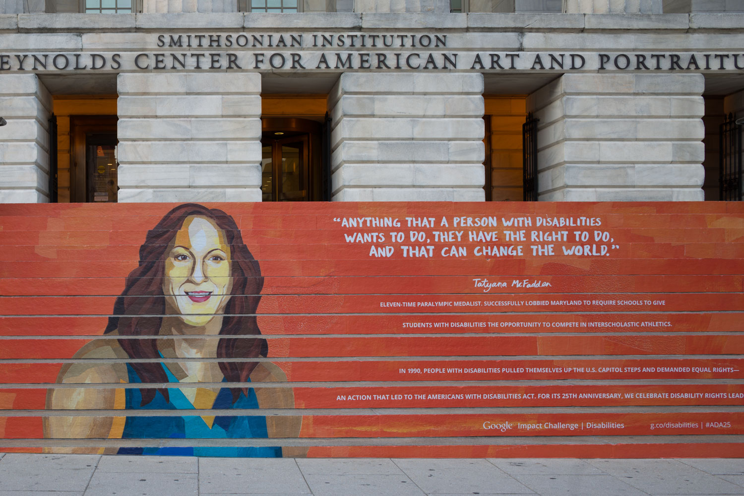 Installation on museum front steps commemorating ADA anniversary -- portraits of ADA pioneers covering the steps