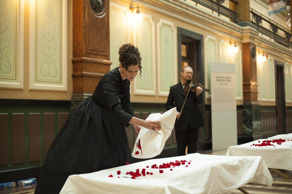 Martha McDonald performing, putting rose petals on beds, in reference to the Civil War soldiers hospitalized at the old Patent Office Building