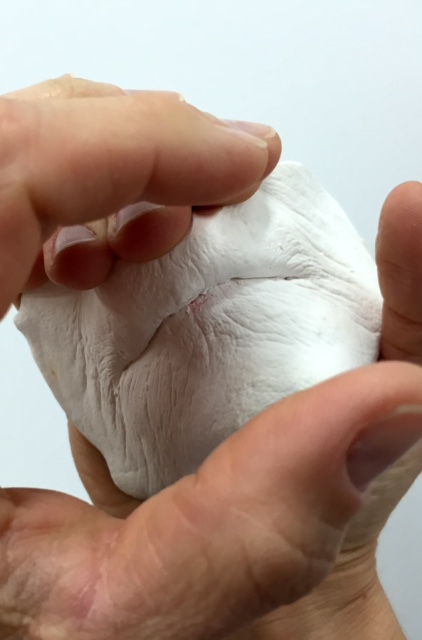 Close-up of a plaster mouth being held by two hands