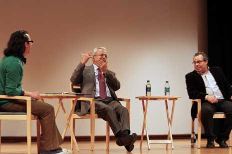 Speakers on stage, sitting on chairs