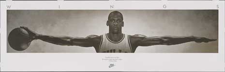 Photograph of Michael Jordan with his arms outstretched, palming a basketball