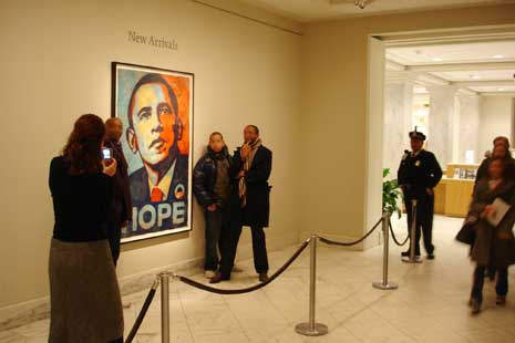 People taking photos of themselves standing next to Obama portrait