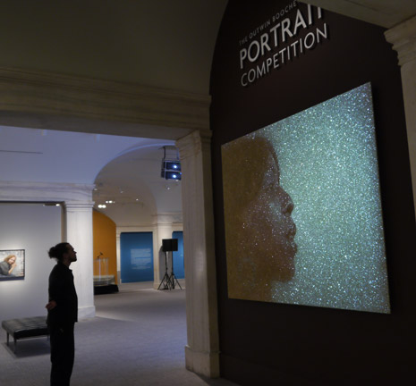 Museum visitor looking at projection portrait in the exhibition