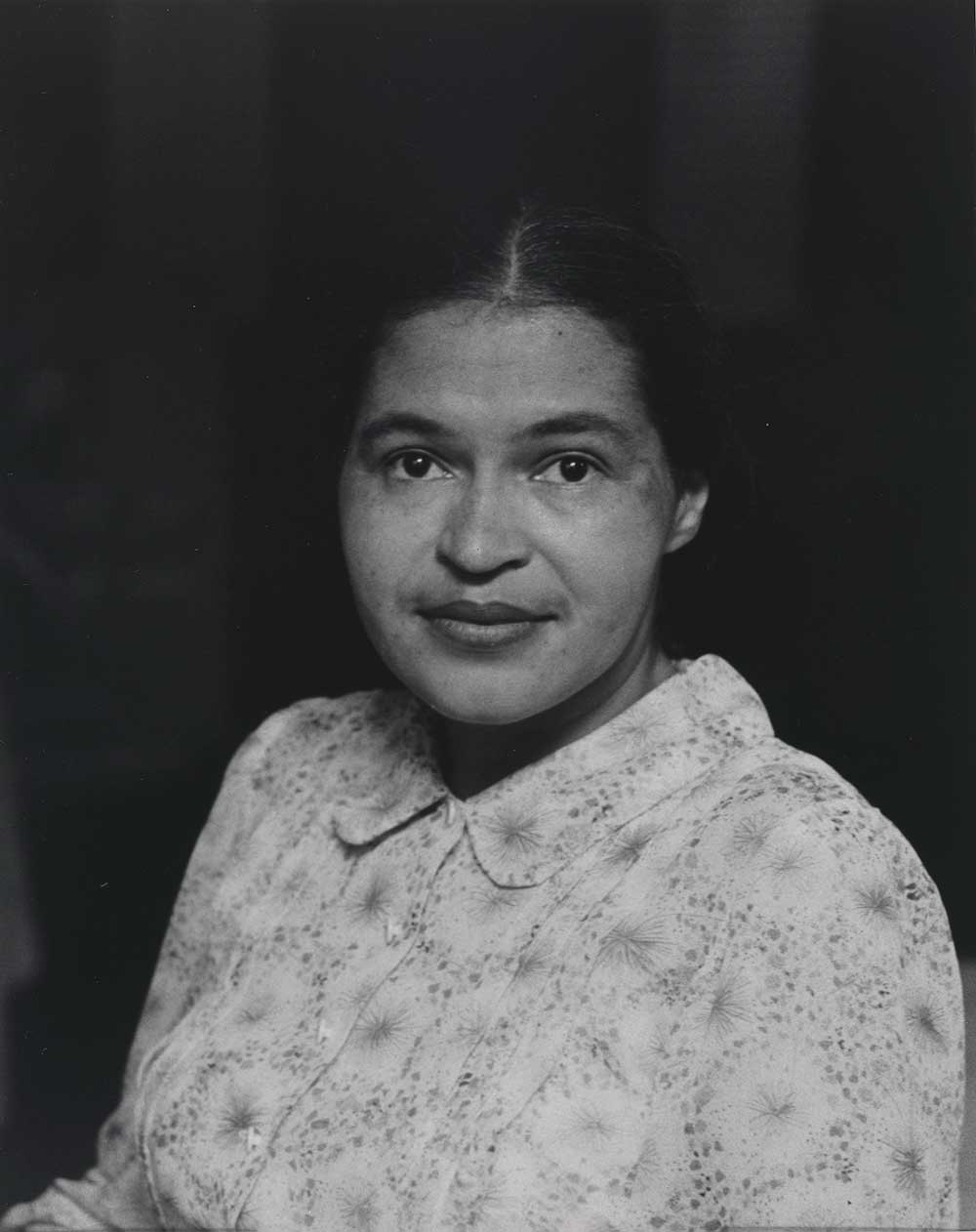 Black and white image of woman wearing white dress and smiling softly