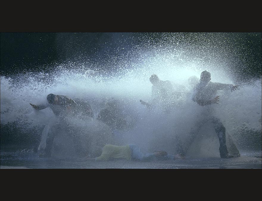 Groups of people being sprayed with water by a high-powered hose