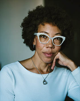 woman with curly hair and glasses