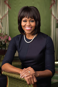 woman in a black dress seated in a green chair