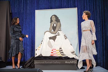 two women standing near an unveiled portrait