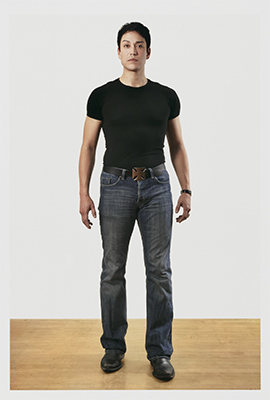full length portrait of a young Asian man in jeans and a black shirt