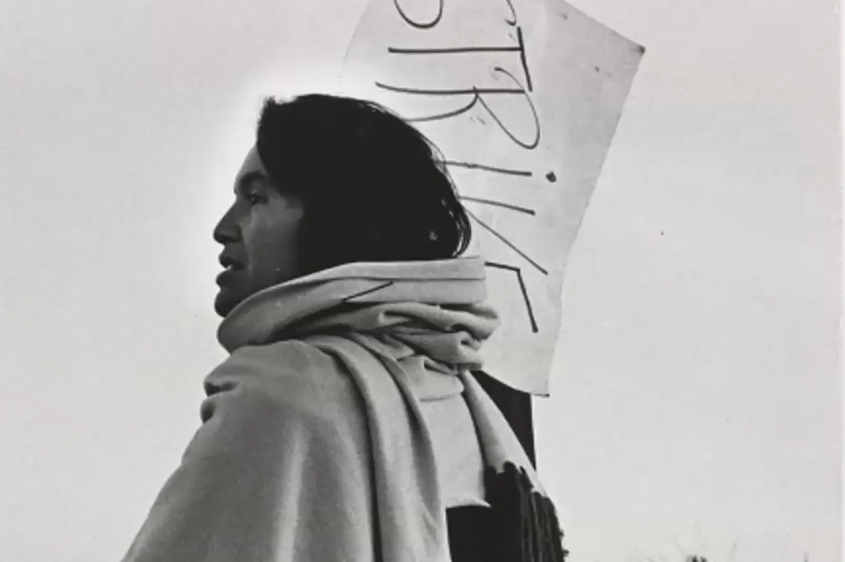 black and white photo of a woman holding a protest sign