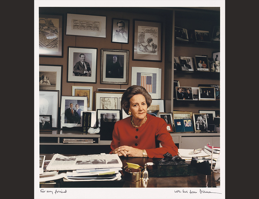 WOman in a red dress seated in her office