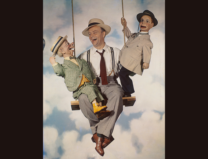 Man on a swing with two ventrilloquist dummies