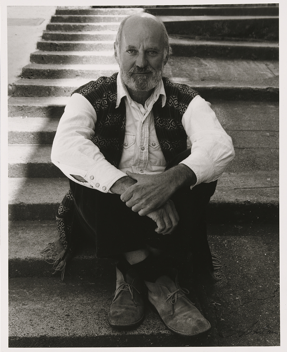 black and white photo of a man sitting on outdoor steps