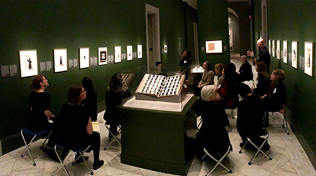 group of people listening to a lecture in a gallery