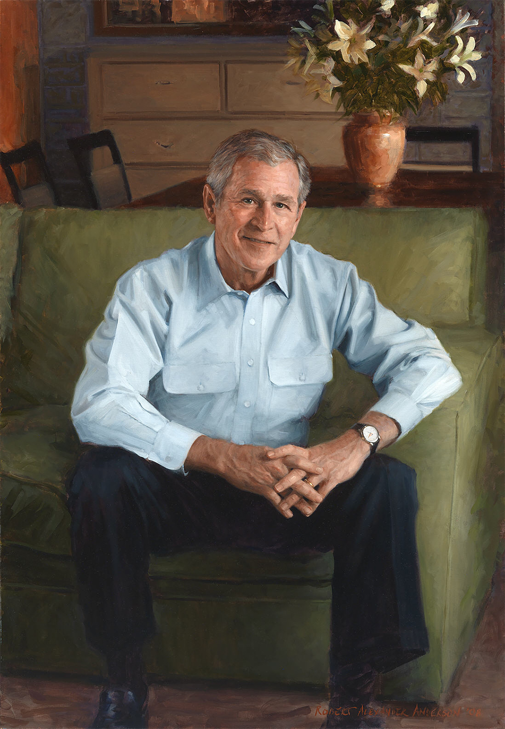 casual portrait of a man in a blue shirt sitting in a green chair